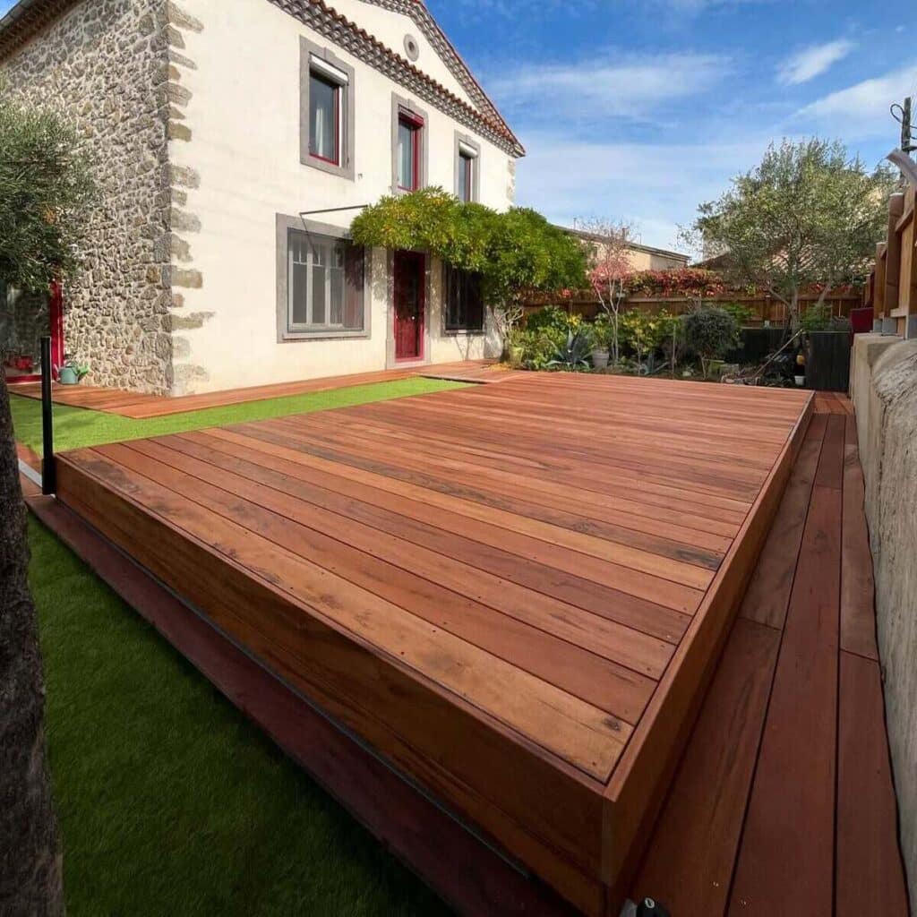 Terrasse en bois devant une maison traditionnelle, ajoutant une touche chaleureuse et naturelle à l'architecture. ​​