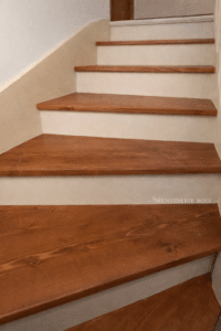 Escalier tournant Menuiserie Boix avec marches en bois brun et contremarches claires.